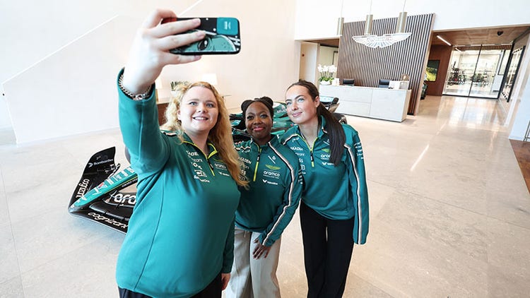 3 young women in tech taking a selfie at the Aston Martin Aramco racing team campus