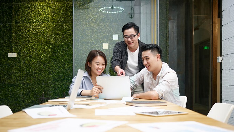 three employees collaborating in a conference room