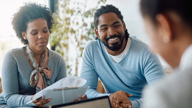 Future of insurance: two people smiling and talking to an insurance agent