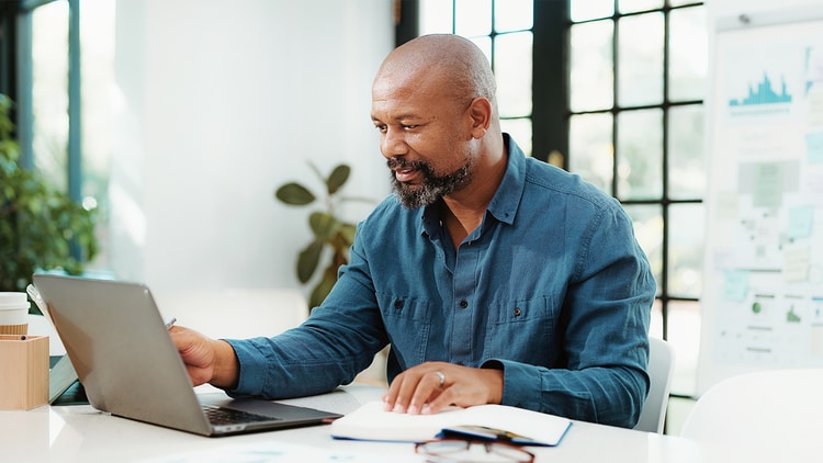 Man sitting at a desk working on a laptop
