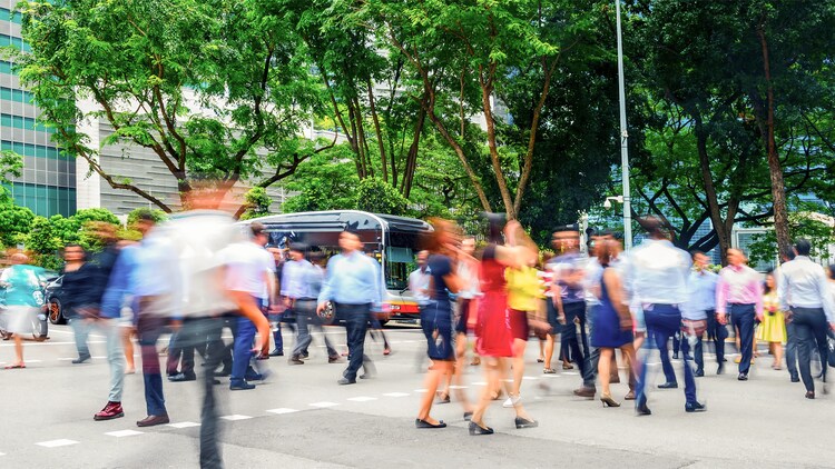 People crossing a Singapore city street with motion blur