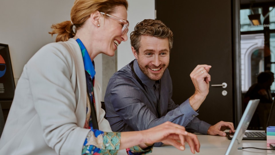 Een man en een vrouw praten terwijl ze op een blauwe bank zitten