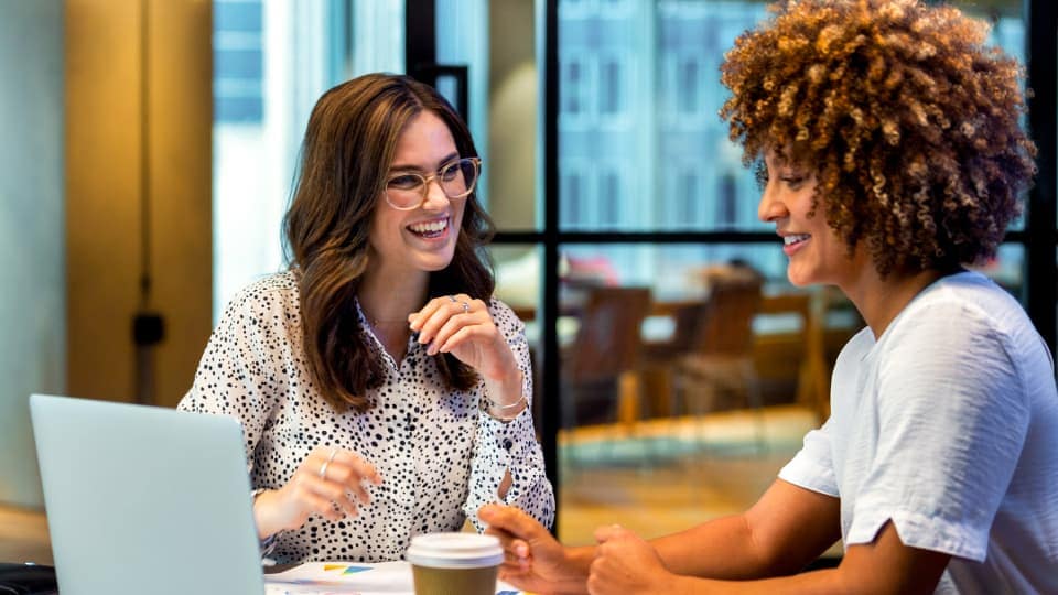 Two HR colleagues review how autonomous workflows are handling routine requests, giving them time to take on more strategic work.