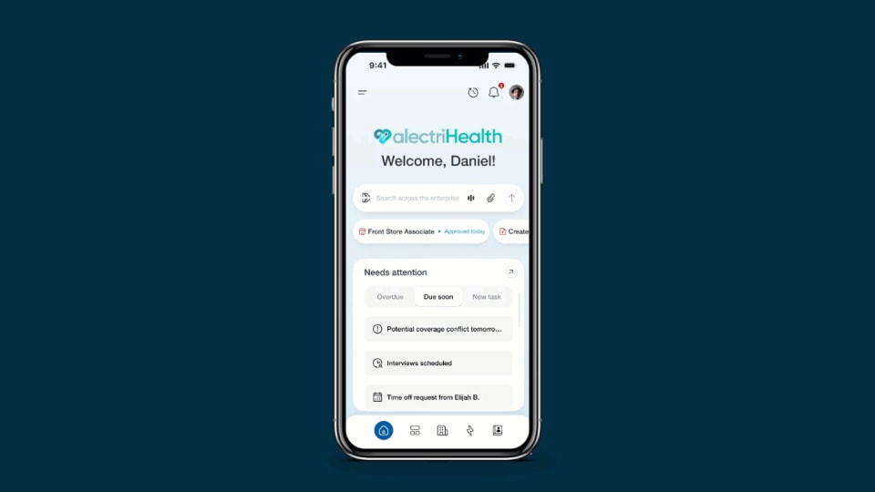 Mobiltelefonbildschirm mit der personalisierten Homepage einer KI-Plattform für das Gesundheitswesen mit Begrüßungsnachricht für Mitarbeiter und Such-/Prompt-Leiste.