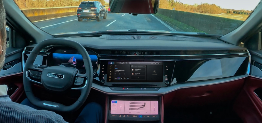 Una persona all'interno di un'auto, che guida e guarda la strada