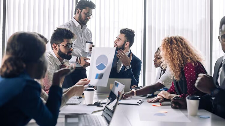 Low-Code-Tools: Mitarbeiter arbeiten an einem Konferenztisch zusammen