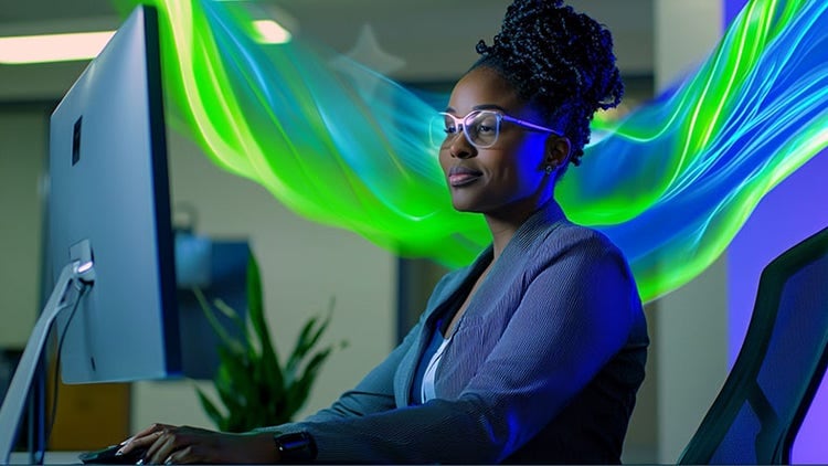 Frau sitzt an einem Computer mit einer grünblauen Schleierform hinter ihr, die die Kontinuität der ServiceNow Platform darstellt