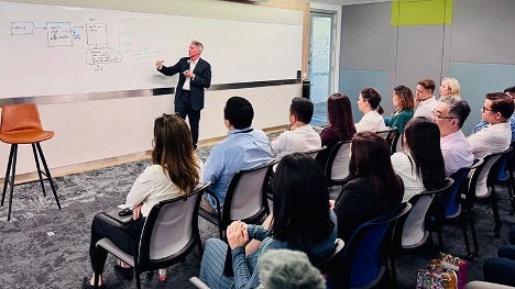 Pat Casey, Chief Technology Officer bei ServiceNow, schreibt auf einem Whiteboard vor einem sitzenden Publikum