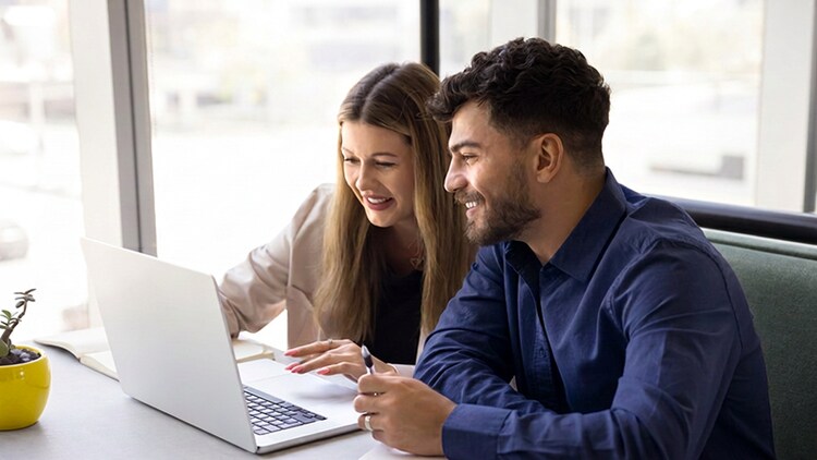 Zwei Fachleute coachen sich am Laptop in hellem Büro