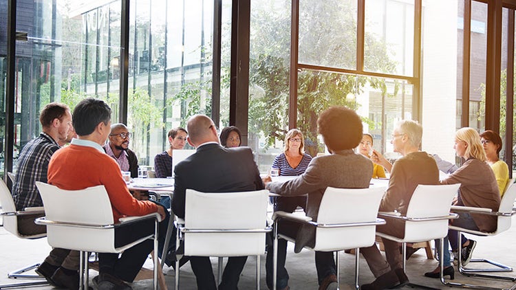 Diverses Team in einem modernen Glaskonferenzraum zusammenarbeiten