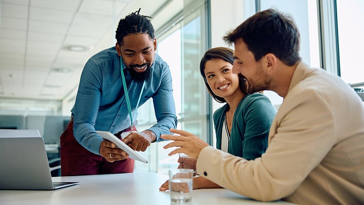Ein Finanzberater verwendet ein Touchpad beim Meeting mit Kunden im Büro