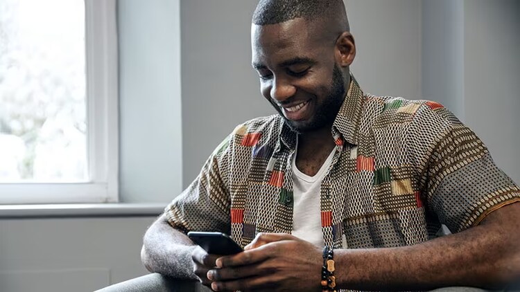 Améliorer l’expérience des employés : un homme souriant interagit avec son smartphone