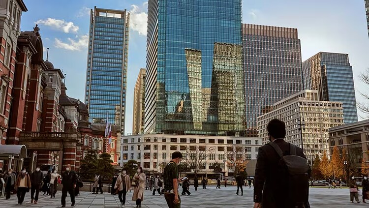 Technology giant Fujitsu: people walking outdoors in Tokyo surrounded by tall buildings