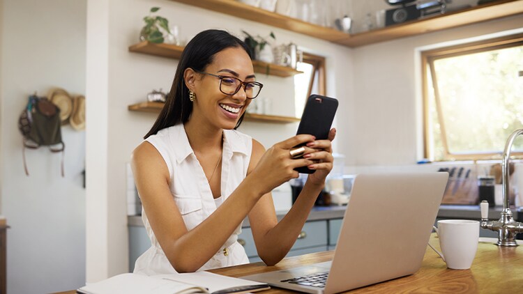 Service client exceptionnel : femme en télétravail, souriant à son téléphone