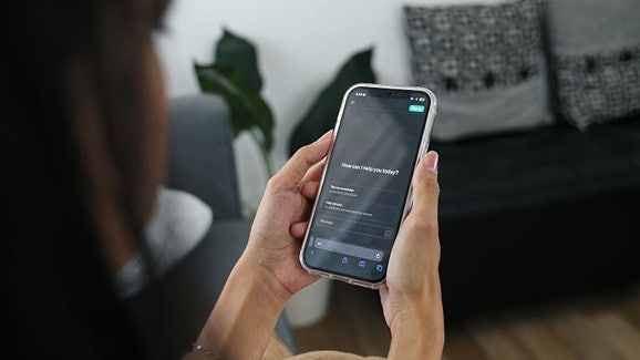 Productivité IA : femme regardant une invite IA sur un smartphone qu’elle tient dans ses mains
