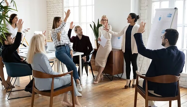 Fonctions RH : des employés engagés qui lèvent la main lors d'une réunion d'entreprise
