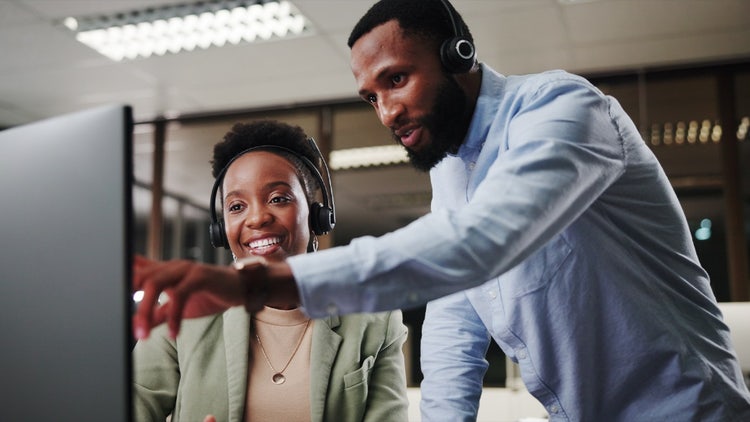 Réinventer la CRM : deux employés du service clientèle regardant un écran d'ordinateur