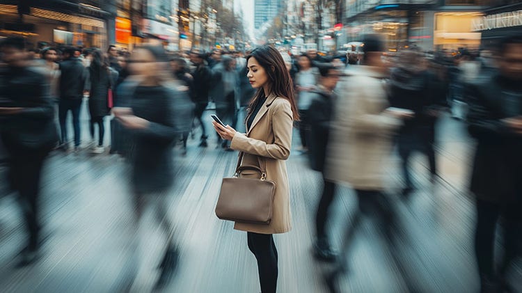 Femme regardant son téléphone dans une rue animée où les gens se bousculent