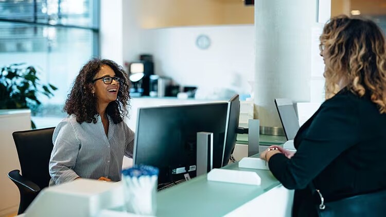 De publieke sector transformeren: een vriendelijke beheerder assisteert een vrouw aan de receptie