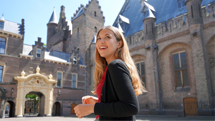 Lachend persoon buiten bij een overheidsgebouw