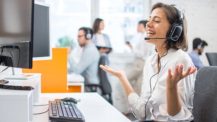 Lachende vrouw met een headset tijdens een videogesprek