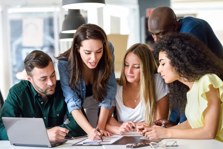 People gathered around a laptop.