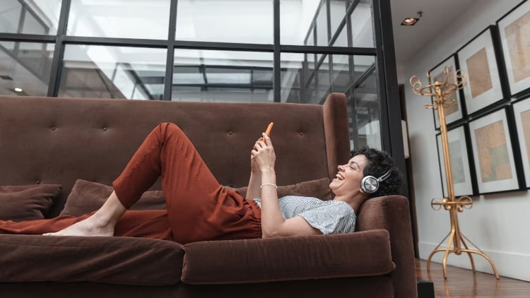 Women laying on couch on phone.
