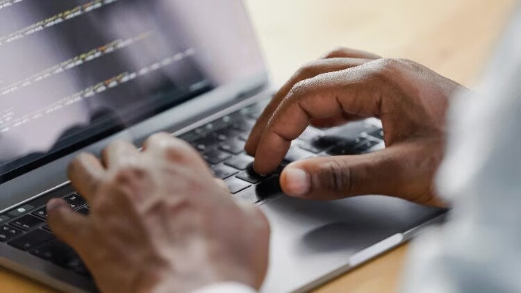 Man typing on a laptop.