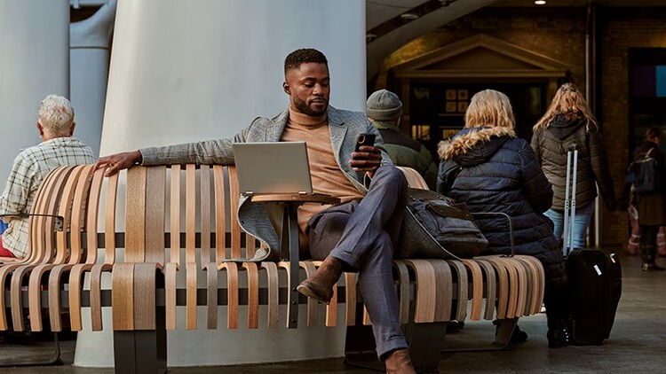 Man sitting on bench with computer