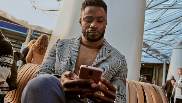 Man sitting on bench with computer