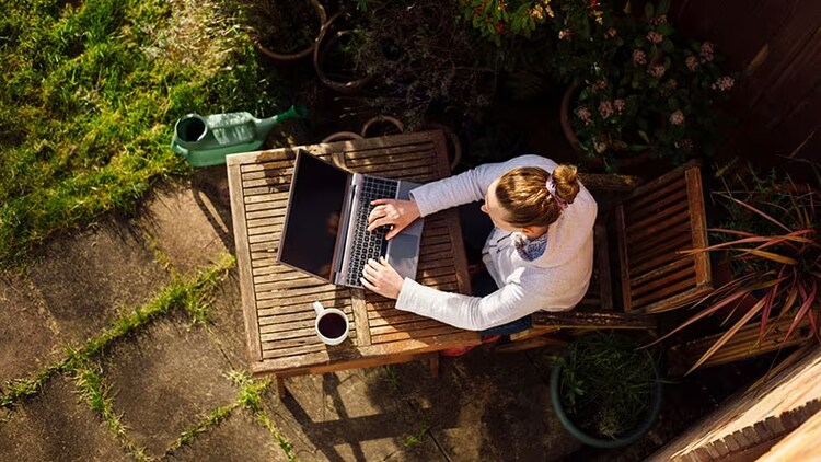Future of banking: woman works on a laptop outdoors