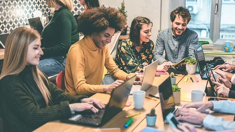 A diverse group of colleagues working on their laptops.