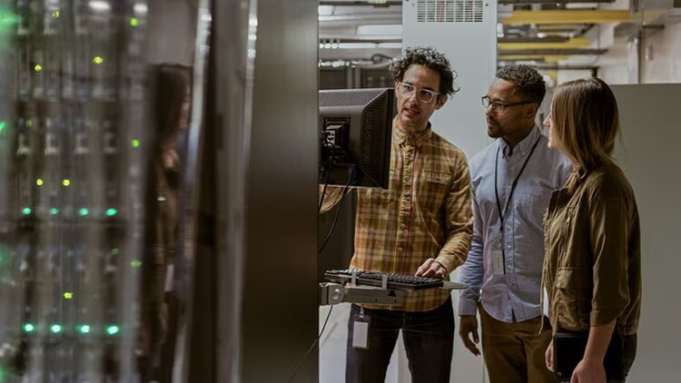 AIOps platforms: 3 workers looking at a monitor