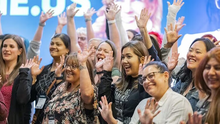 Knowledge 2023 takeaways: a group of women raising their hands