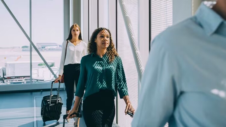 Satisfying customer journeys: two women pulling suitcases through an airport