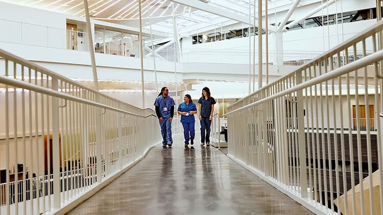 Employee experience in healthcare: 3 healthcare workers walking down a corridor