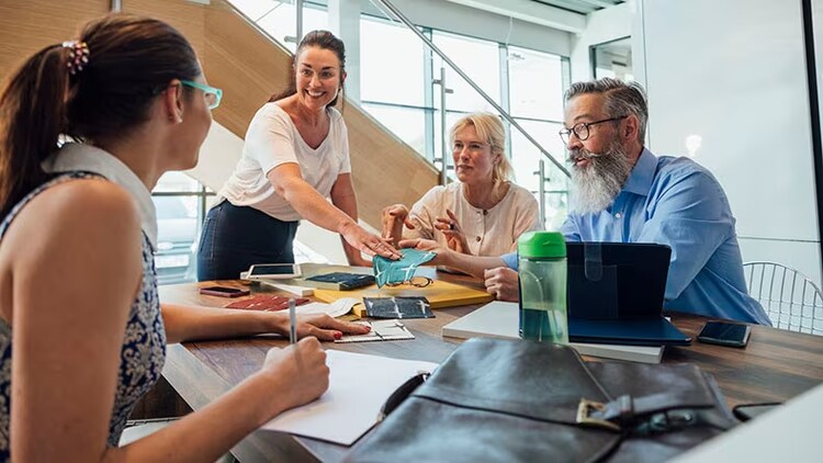 Customer satisfaction metrics: group of smiling people around a conference table