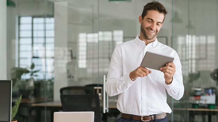 Procurement process: smiling man in office using a tablet