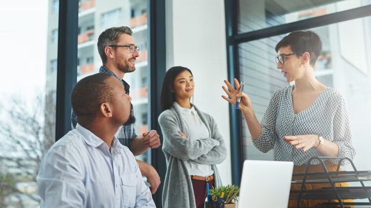 Overcoming operational challenges: woman holding marker talks to 3 co-workers