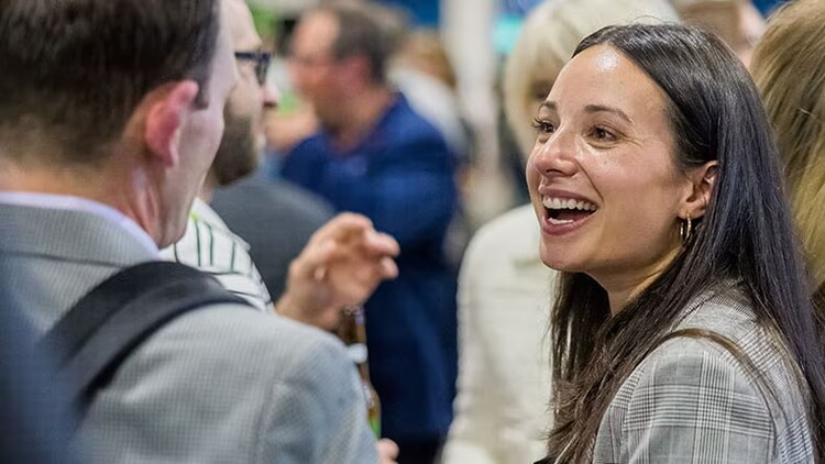 ServiceNow Knowledge: two businesspeople chatting in a crowd
