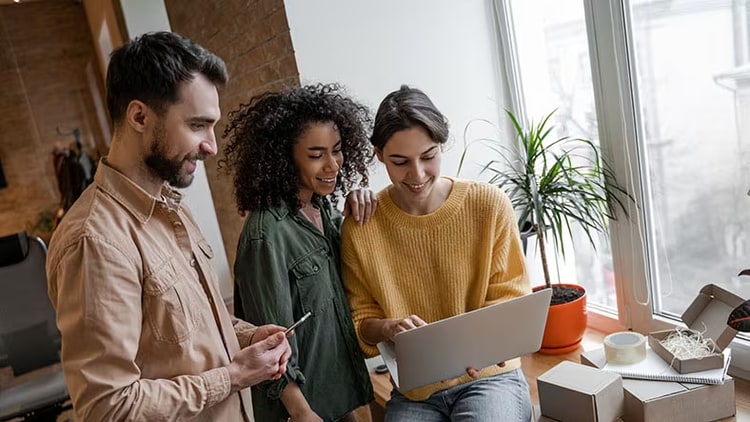 Global Business Services: Three people looking at a laptop
