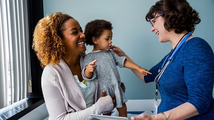 Patient care: Mother and daughter being seen by a doctor.