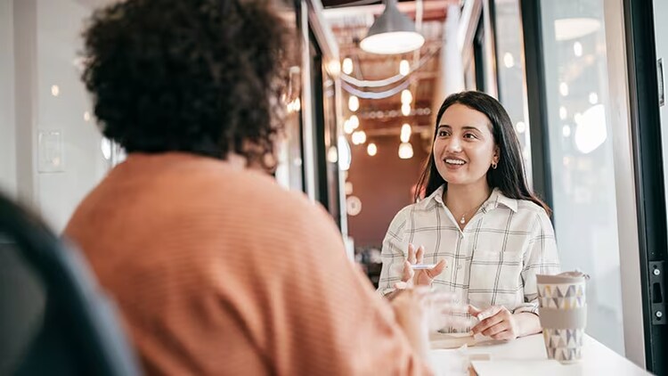 Career shift: two women in conversation at a table in an office