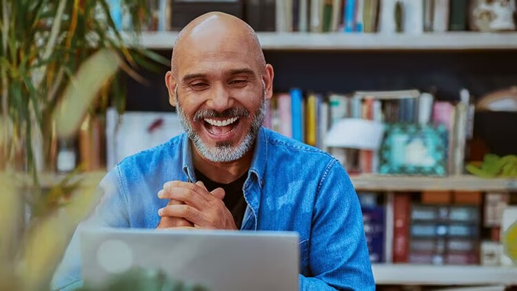 Employee engagement: Male smiling at laptop