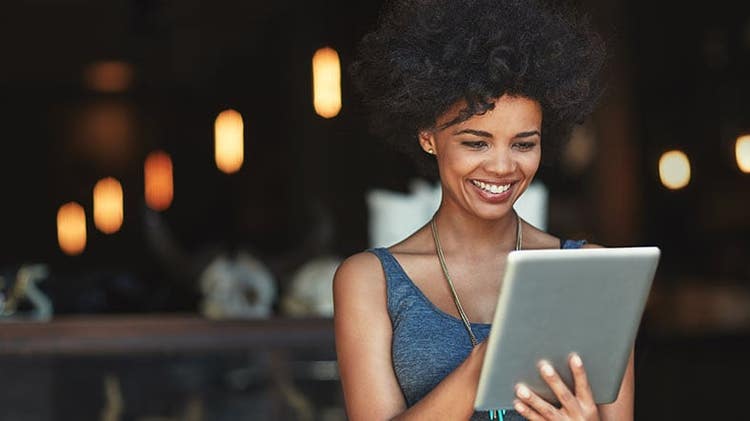 Customer experience landscape: woman smiling at tablet in her hands