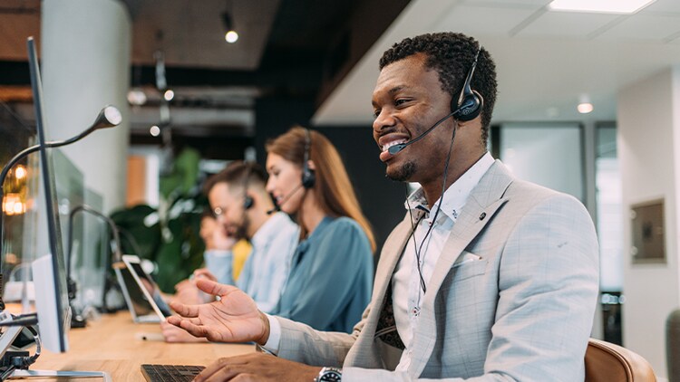 Contact center as a service: a line of customer service agents wearing headsets working in an office