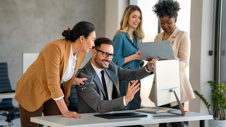 AI success: group of workers excitedly looking at computer screens