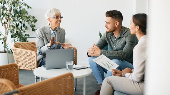 UK public sector: Three people seated, having a meeting