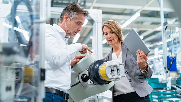 Intelligent automation: man and woman examining robotic machinery