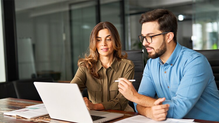 Drive business transformation: two employees working at a laptop in an office